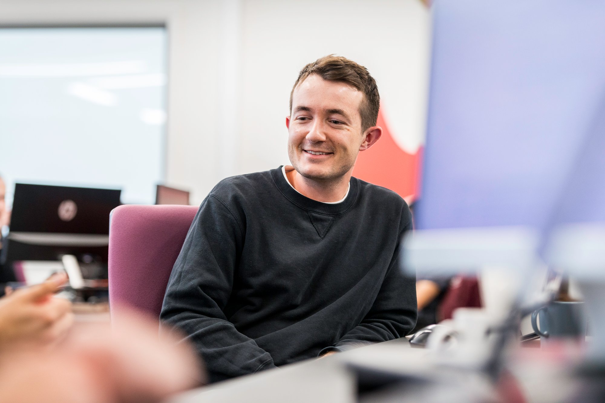 Man smiling in UK office Andrew Thomas Avidly